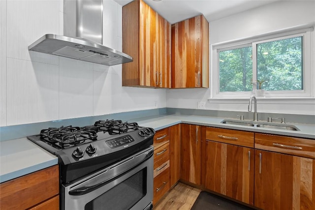 1407 Spring Gdn, Austin, TX 78746 - kitchen featuring stainless steel gas stove, wall chimney exhaust hood, brown cabinets, and light countertops