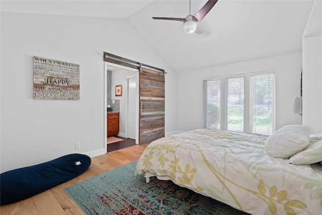 1407 Spring Gdn, Austin, TX 78746 - bedroom featuring a barn door, wood finished floors, lofted ceiling, a ceiling fan, and ensuite bath