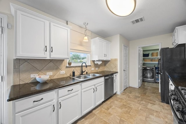 120 Hawkins Ct, Hutto, TX 78634 - kitchen with stainless steel dishwasher, washer / dryer, range with gas stovetop, white cabinetry, and decorative backsplash