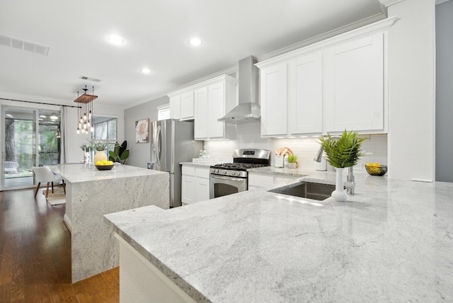 6116 Whipple Way, Austin, TX 78745 - kitchen featuring stainless steel appliances, wall chimney range hood, light stone counters, tasteful backsplash, and recessed lighting