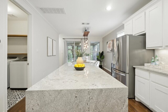 6116 Whipple Way, Austin, TX 78745 - kitchen featuring dark wood-type flooring, ornamental molding, a kitchen island, stainless steel refrigerator with ice dispenser, and white cabinetry