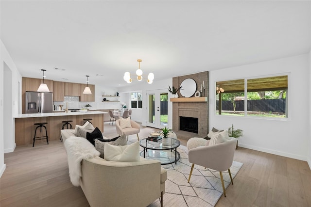6721 Lost Vly, Austin, TX 78745 - living room with light wood-style floors, a chandelier, and a brick fireplace