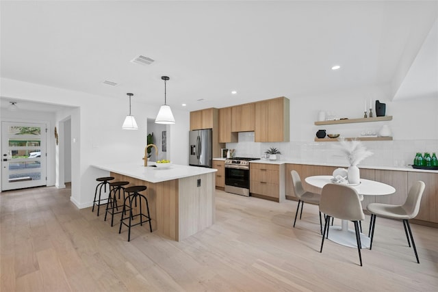 6721 Lost Vly, Austin, TX 78745 - kitchen with appliances with stainless steel finishes, modern cabinets, backsplash, a breakfast bar area, and recessed lighting