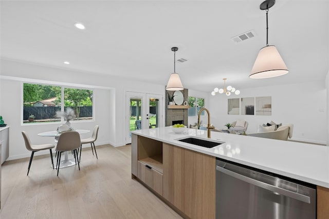 6721 Lost Vly, Austin, TX 78745 - kitchen with stainless steel dishwasher, modern cabinets, light countertops, pendant lighting, and light wood-style flooring