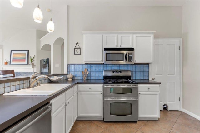 9012 Meacham Way, Austin, TX 78749 - kitchen with appliances with stainless steel finishes, dark countertops, light tile patterned floors, decorative backsplash, and white cabinets