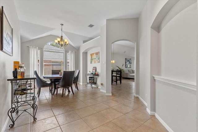 9012 Meacham Way, Austin, TX 78749 - dining space featuring arched walkways, light tile patterned floors, vaulted ceiling, and a chandelier