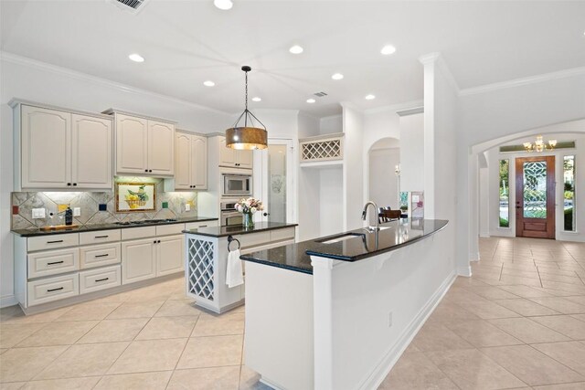 1500 El Cielo, Leander, TX 78641 - kitchen featuring stainless steel appliances, arched walkways, light tile patterned flooring, crown molding, and backsplash