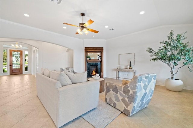 1500 El Cielo, Leander, TX 78641 - living area with light tile patterned floors, arched walkways, recessed lighting, a warm lit fireplace, and crown molding