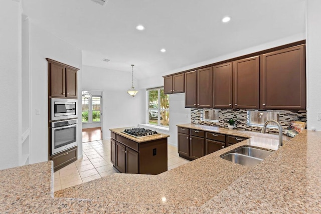 13121 Armaga Springs Rd, Austin, TX 78727 - kitchen with appliances with stainless steel finishes, backsplash, light tile patterned floors, light stone countertops, and recessed lighting
