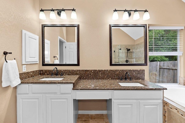 13121 Armaga Springs Rd, Austin, TX 78727 - bathroom with double vanity, a tile shower, a tub, tile patterned flooring, and a textured wall