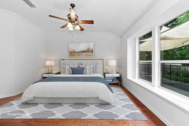 13121 Armaga Springs Rd, Austin, TX 78727 - bedroom featuring lofted ceiling, crown molding, multiple windows, wood finished floors, and a ceiling fan