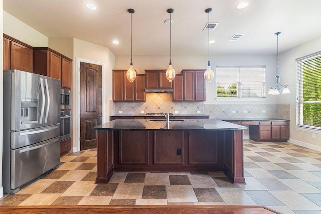 2713 Windy Vane Dr, Pflugerville, TX 78660 - kitchen with appliances with stainless steel finishes, backsplash, dark stone counters, recessed lighting, and hanging light fixtures