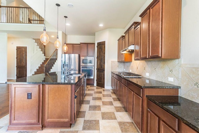 2713 Windy Vane Dr, Pflugerville, TX 78660 - kitchen featuring appliances with stainless steel finishes, brown cabinets, tasteful backsplash, dark stone counters, and recessed lighting
