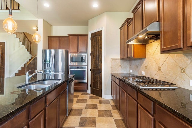 2713 Windy Vane Dr, Pflugerville, TX 78660 - kitchen with appliances with stainless steel finishes, under cabinet range hood, decorative light fixtures, dark stone counters, and recessed lighting