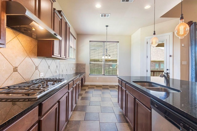 2713 Windy Vane Dr, Pflugerville, TX 78660 - kitchen with appliances with stainless steel finishes, range hood, decorative backsplash, dark stone counters, and recessed lighting