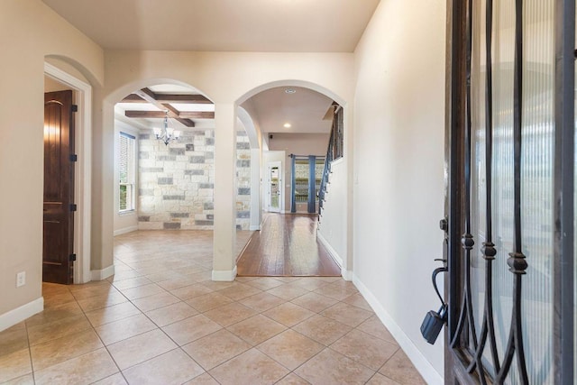 2713 Windy Vane Dr, Pflugerville, TX 78660 - foyer entrance featuring coffered ceiling, light tile patterned floors, arched walkways, beam ceiling, and a chandelier
