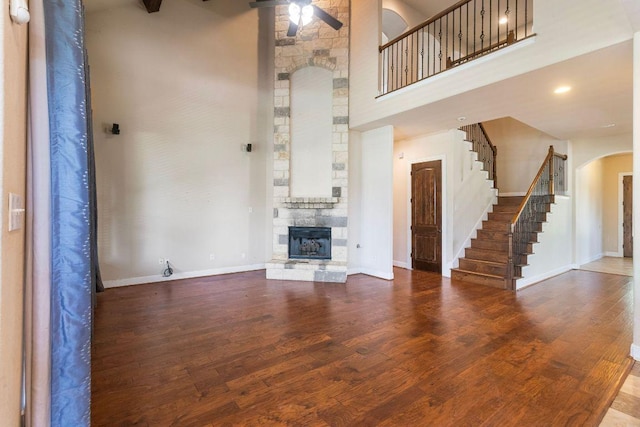 2713 Windy Vane Dr, Pflugerville, TX 78660 - unfurnished living room with a high ceiling, arched walkways, ceiling fan, a fireplace, and stairway