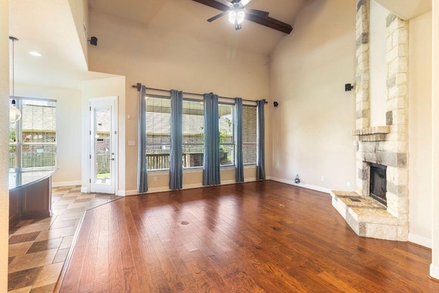 2713 Windy Vane Dr, Pflugerville, TX 78660 - unfurnished living room featuring a fireplace, a ceiling fan, hardwood / wood-style flooring, high vaulted ceiling, and beam ceiling