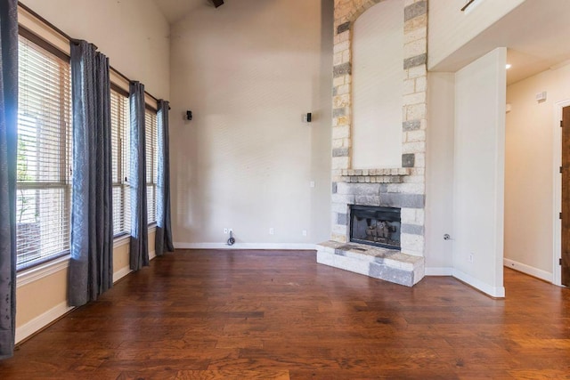 2713 Windy Vane Dr, Pflugerville, TX 78660 - unfurnished living room featuring wood finished floors, a stone fireplace, and a high ceiling