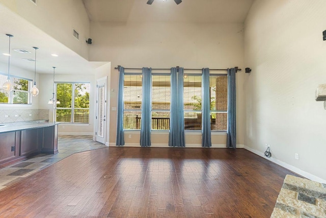 2713 Windy Vane Dr, Pflugerville, TX 78660 - unfurnished living room with hardwood / wood-style floors, ceiling fan, and a towering ceiling