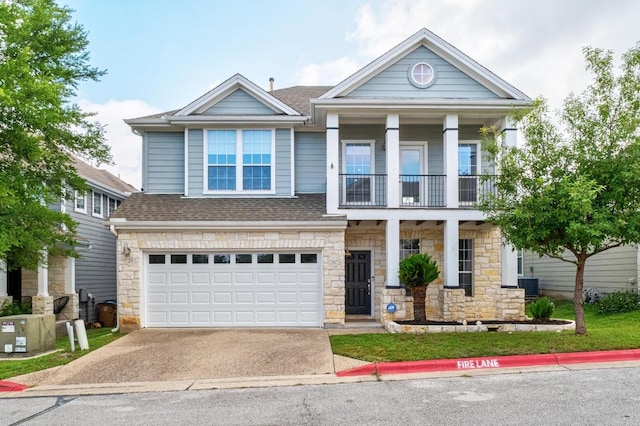 6715 Windrift Way Unit 29, Austin, TX 78745 - view of front of property with stone siding, a balcony, a shingled roof, and driveway