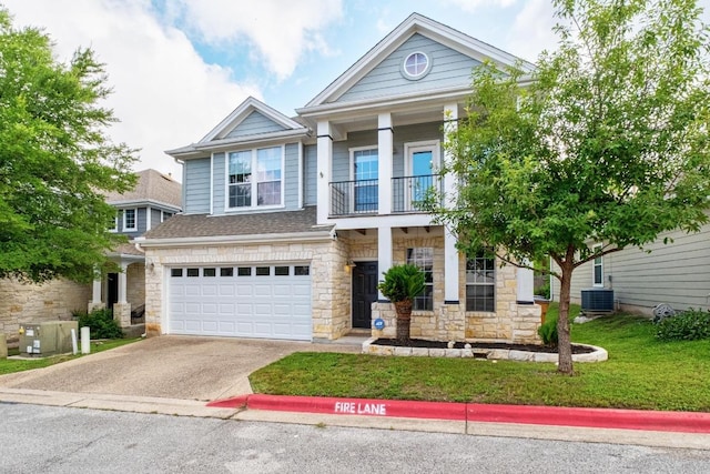 6715 Windrift Way Unit 29, Austin, TX 78745 - view of front of house featuring stone siding, a balcony, concrete driveway, a front lawn, and a garage