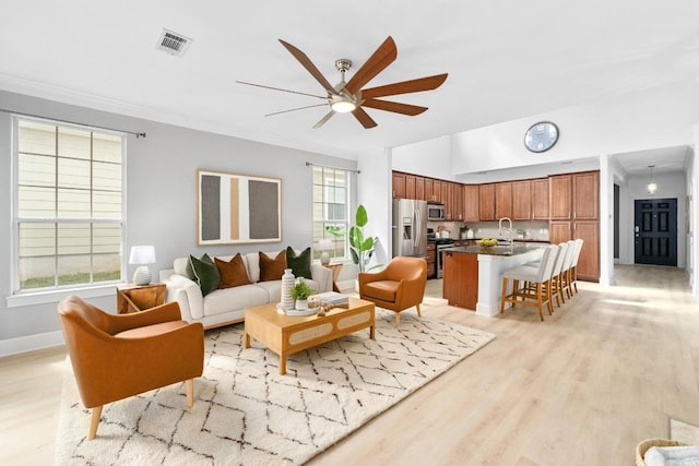 6715 Windrift Way Unit 29, Austin, TX 78745 - living area featuring a ceiling fan, light wood finished floors, and ornamental molding