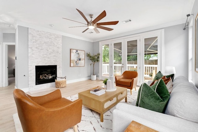 6715 Windrift Way Unit 29, Austin, TX 78745 - living area featuring crown molding, ceiling fan, wood finished floors, and a fireplace