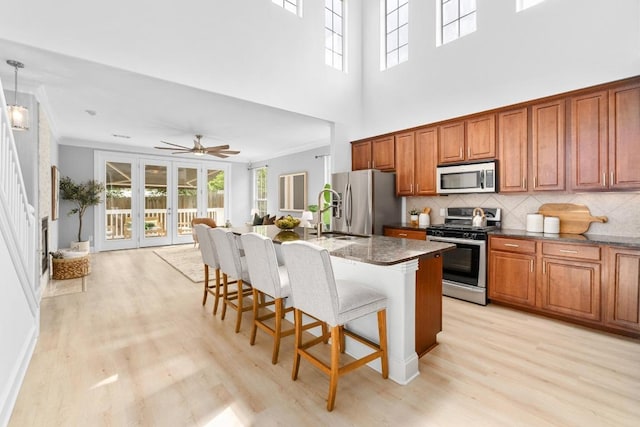 6715 Windrift Way Unit 29, Austin, TX 78745 - kitchen featuring stainless steel appliances, light wood finished floors, ornamental molding, backsplash, and healthy amount of natural light