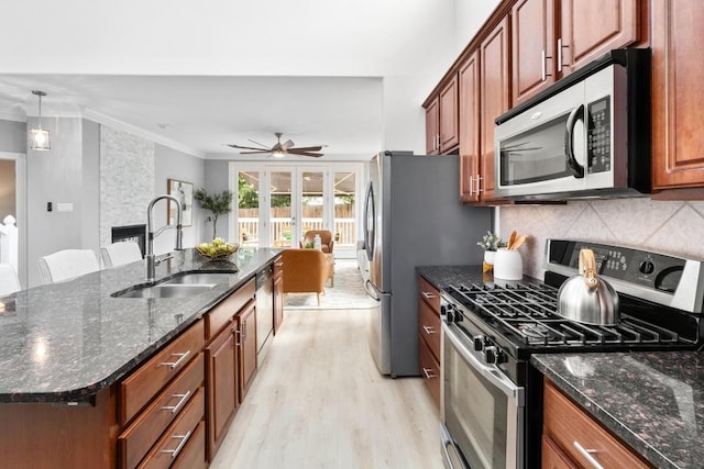 6715 Windrift Way Unit 29, Austin, TX 78745 - kitchen featuring stainless steel appliances, light wood-type flooring, a ceiling fan, decorative backsplash, and crown molding