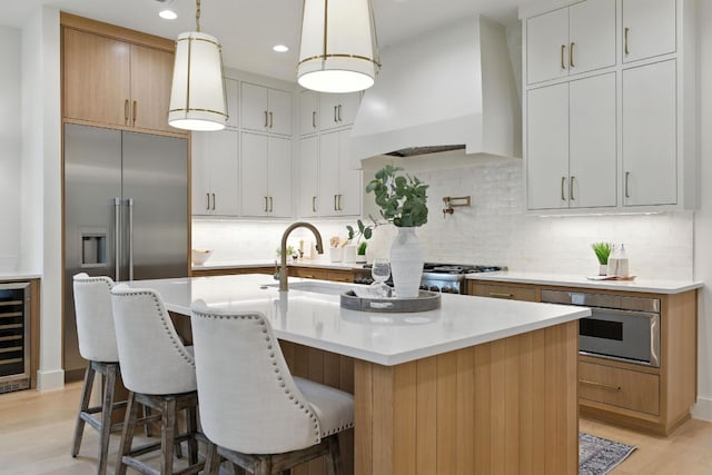 2007 Pasadena Dr, Austin, TX 78757 - kitchen with custom range hood, light wood-style floors, light countertops, wine cooler, and tasteful backsplash