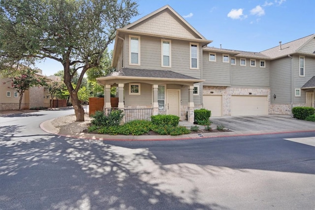 11000 Anderson Mill Rd Unit 52, Austin, TX 78750 - view of front facade featuring asphalt driveway, a garage, covered porch, and stone siding