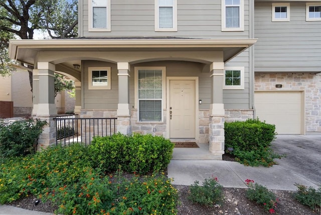 11000 Anderson Mill Rd Unit 52, Austin, TX 78750 - doorway to property featuring stone siding, a garage, covered porch, and driveway