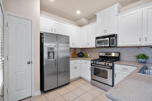 11000 Anderson Mill Rd Unit 52, Austin, TX 78750 - kitchen with stainless steel appliances, light tile patterned floors, white cabinetry, and recessed lighting