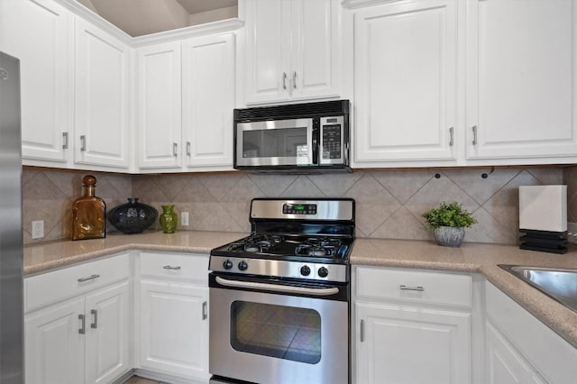 11000 Anderson Mill Rd Unit 52, Austin, TX 78750 - kitchen with stainless steel appliances, white cabinets, light countertops, and tasteful backsplash