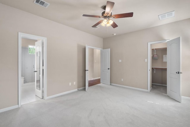 11000 Anderson Mill Rd Unit 52, Austin, TX 78750 - unfurnished bedroom featuring light carpet, a spacious closet, connected bathroom, and ceiling fan