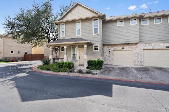 11000 Anderson Mill Rd Unit 52, Austin, TX 78750 - craftsman house featuring driveway, an attached garage, stone siding, and a porch