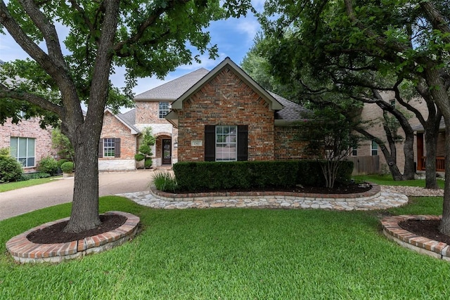 1343 River Forest Dr, Round Rock, TX 78665 - view of front of house with a front yard, brick siding, roof with shingles, and curved driveway