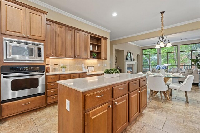 1343 River Forest Dr, Round Rock, TX 78665 - kitchen with appliances with stainless steel finishes, crown molding, a center island, light countertops, and backsplash