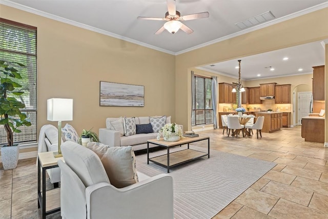1343 River Forest Dr, Round Rock, TX 78665 - living room featuring healthy amount of natural light, ceiling fan, crown molding, stone tile flooring, and arched walkways