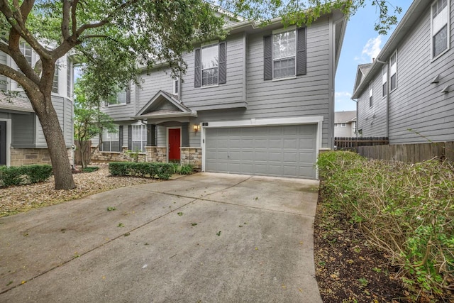 8518 Cahill Dr Unit 23, Austin, TX 78729 - view of front of property featuring driveway, an attached garage, and stone siding