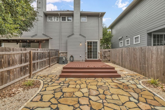 8518 Cahill Dr Unit 23, Austin, TX 78729 - rear view of house featuring a wooden deck, a fenced backyard, a chimney, and a patio