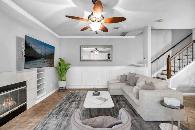 8518 Cahill Dr Unit 23, Austin, TX 78729 - tiled living area with ceiling fan, crown molding, stairway, and a tile fireplace