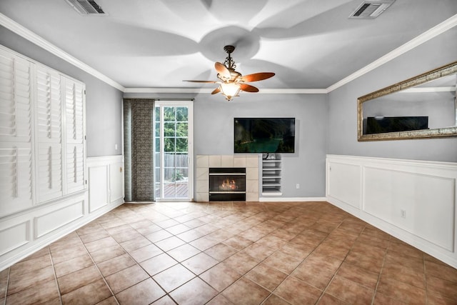 8518 Cahill Dr Unit 23, Austin, TX 78729 - unfurnished living room with a decorative wall, a ceiling fan, crown molding, a fireplace, and a wainscoted wall