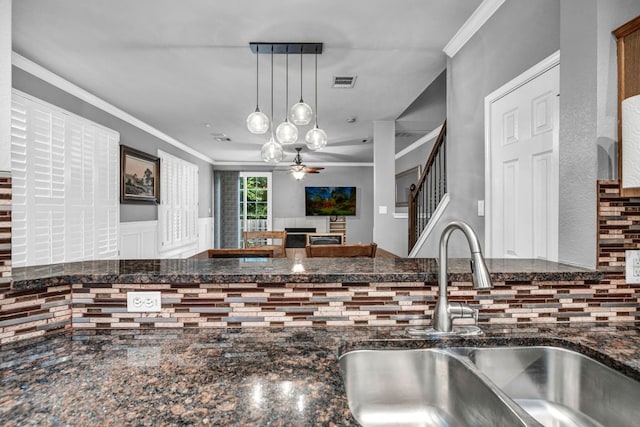 8518 Cahill Dr Unit 23, Austin, TX 78729 - kitchen with decorative backsplash, ornamental molding, dark stone countertops, a ceiling fan, and hanging light fixtures