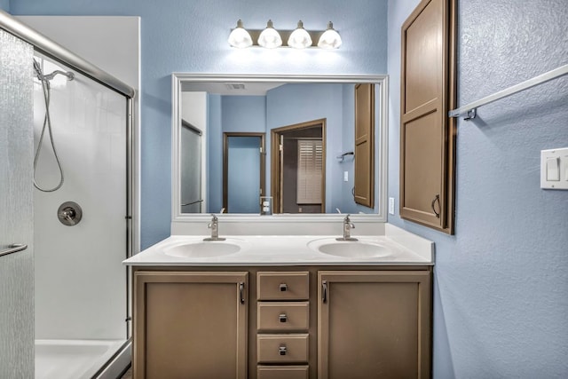 8518 Cahill Dr Unit 23, Austin, TX 78729 - bathroom with an enclosed shower, double vanity, and a textured wall