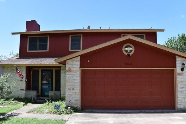 5605 China Berry Rd, Austin, TX 78744 - view of front of home featuring stone siding, a chimney, an attached garage, and concrete driveway