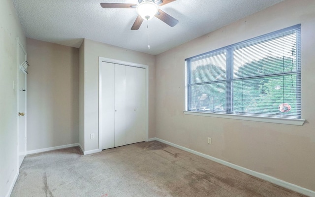 5605 China Berry Rd, Austin, TX 78744 - unfurnished bedroom with carpet flooring, a closet, a textured ceiling, and a ceiling fan