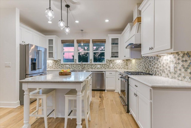 3009 Lawrence Dr, Austin, TX 78734 - kitchen with high end appliances, custom exhaust hood, light wood finished floors, white cabinets, and a kitchen breakfast bar