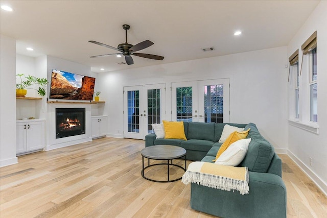 3009 Lawrence Dr, Austin, TX 78734 - living room featuring french doors, light wood finished floors, a ceiling fan, recessed lighting, and a glass covered fireplace